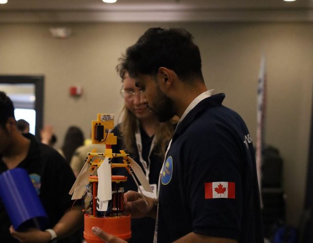 Shayaan holding the team's CanSat with its casing removed